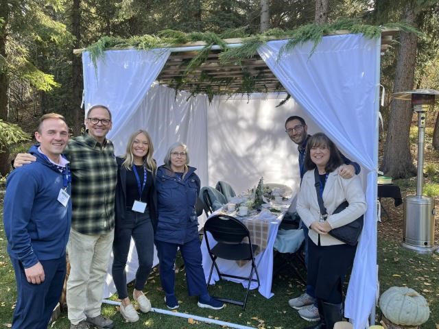 A group of people standing under a white tentDescription automatically generated