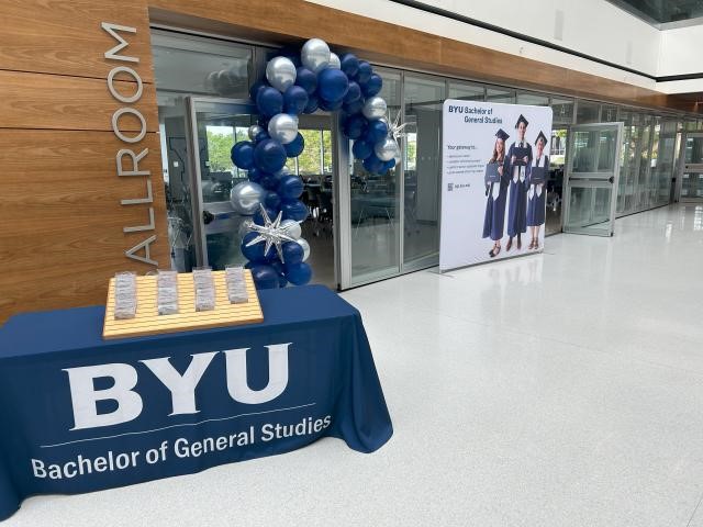 A blue and silver balloon arch in front of a buildingDescription automatically generated