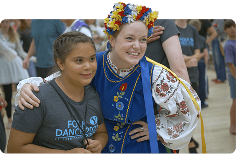 Enriching cultural experiences at Brigham Young University, with two participants at a folk dance event.